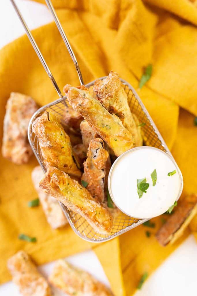 Air Fryer Eggplant Fries in basket with ranch dressing.