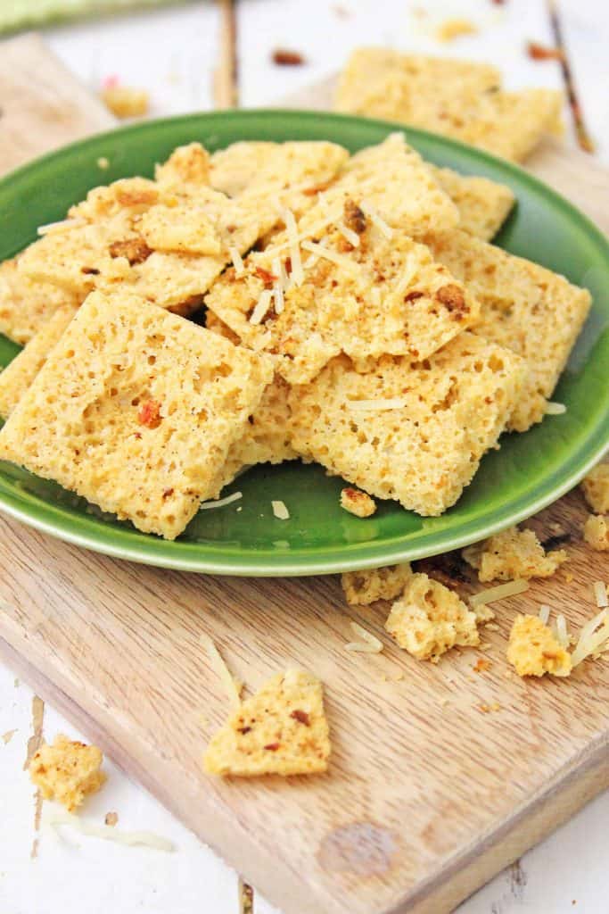 Keto Cheese Crackers on a green plate on a cutting board.
