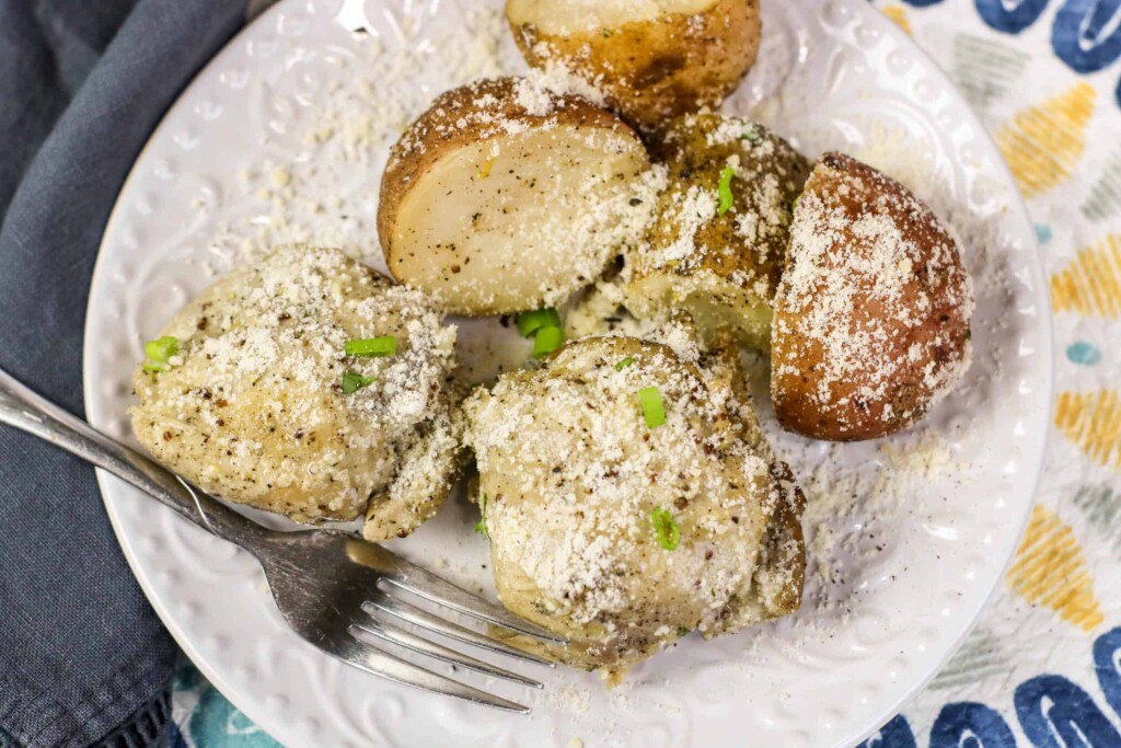 Instant Pot chicken and potatoes on a white plate with a fork on the side.