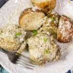 Instant Pot chicken and potatoes on a white plate with a fork on the side.