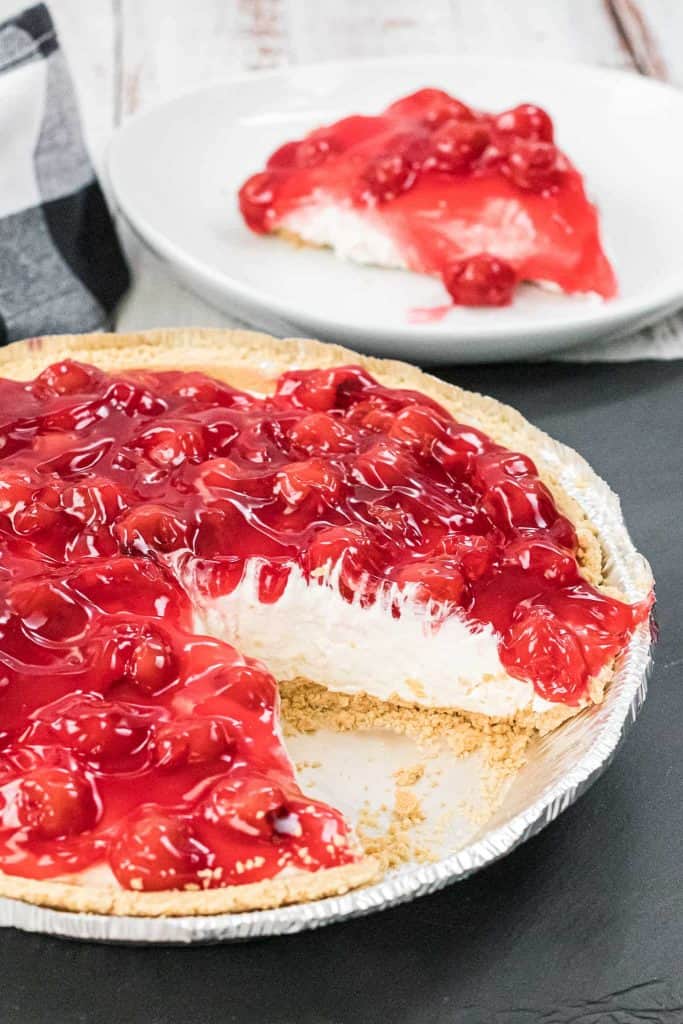 No bake cherry cheesecake with a slice removed.