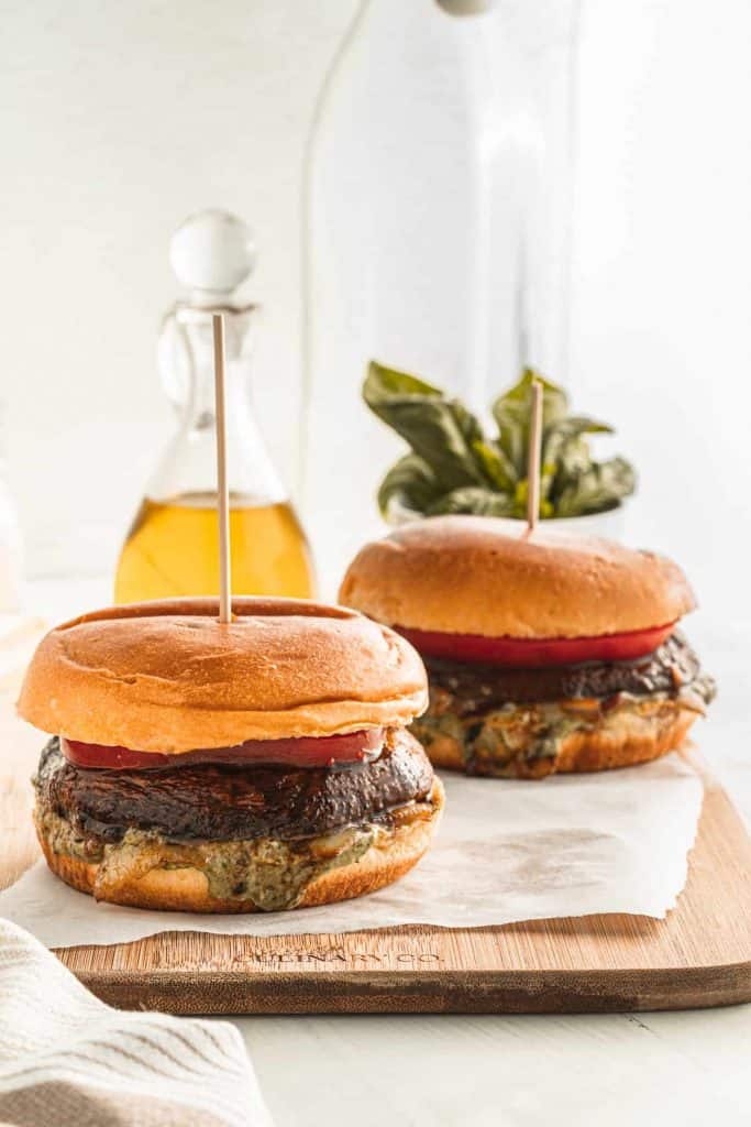2 portobello borders with tomato slice on a counter top.