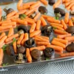Carrots and mushrooms on a baking sheet.