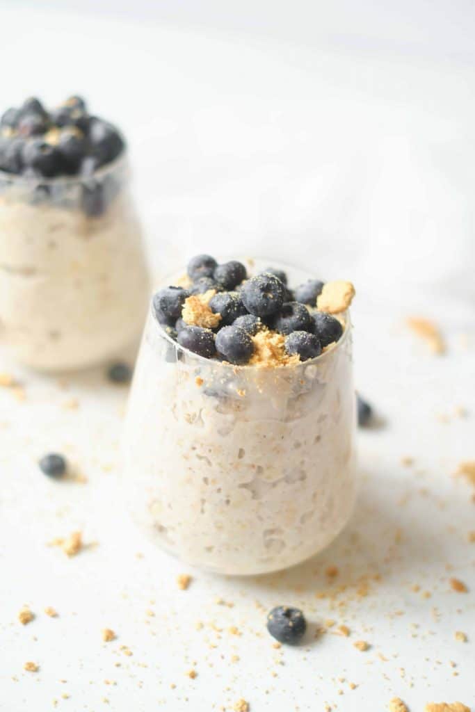 2 cups of overnight oats with blueberries and crushed graham crackers on top.