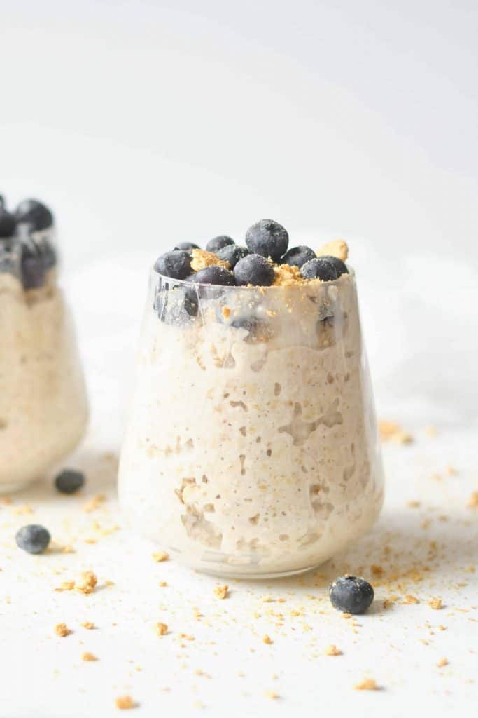 Headon view of oats and blueberries and graham crackers in a cup.