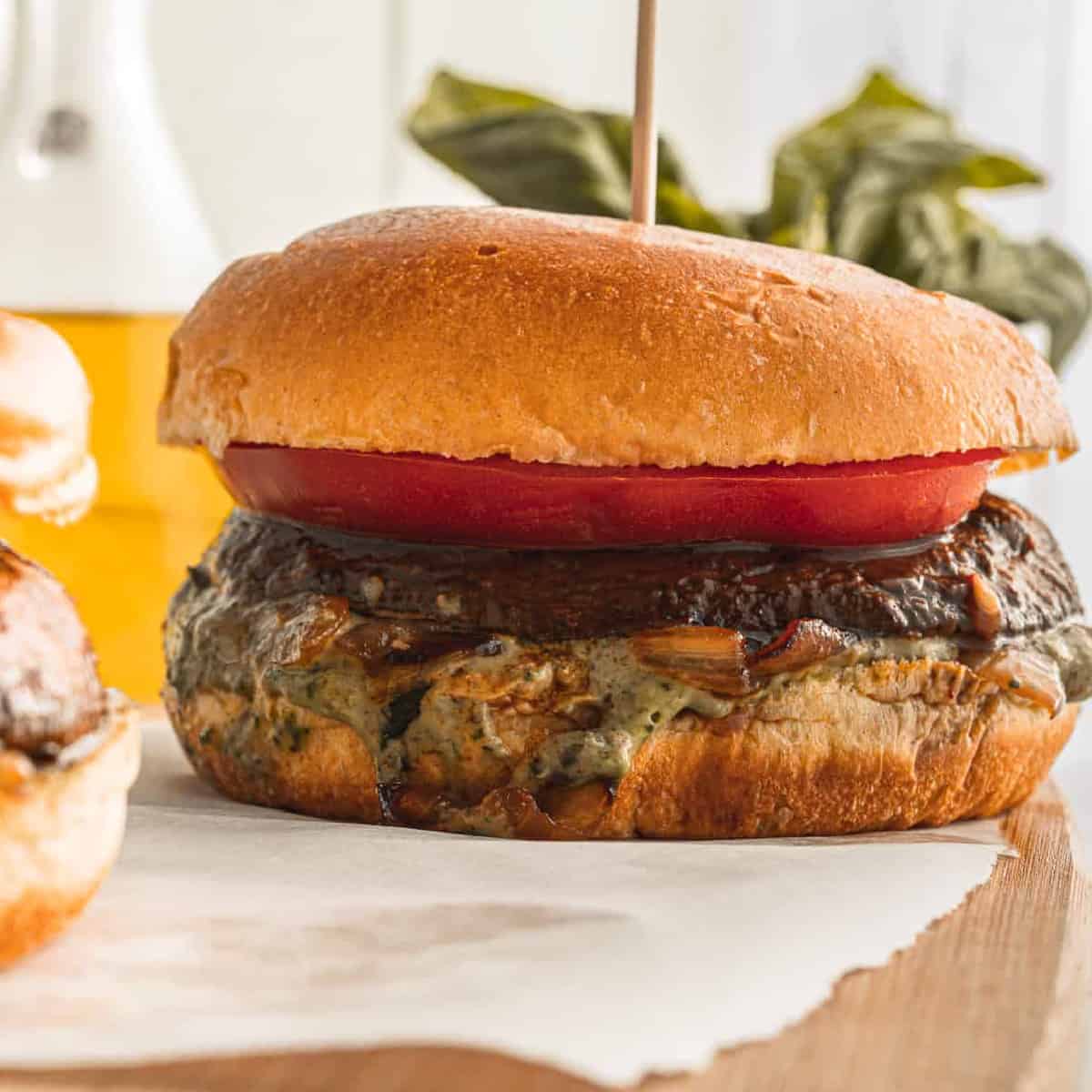 Vegan mushroom burger with tomato slice and toothpick in the center.