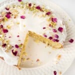 Persian Love Cake on a white plate with a piece cut out of it.