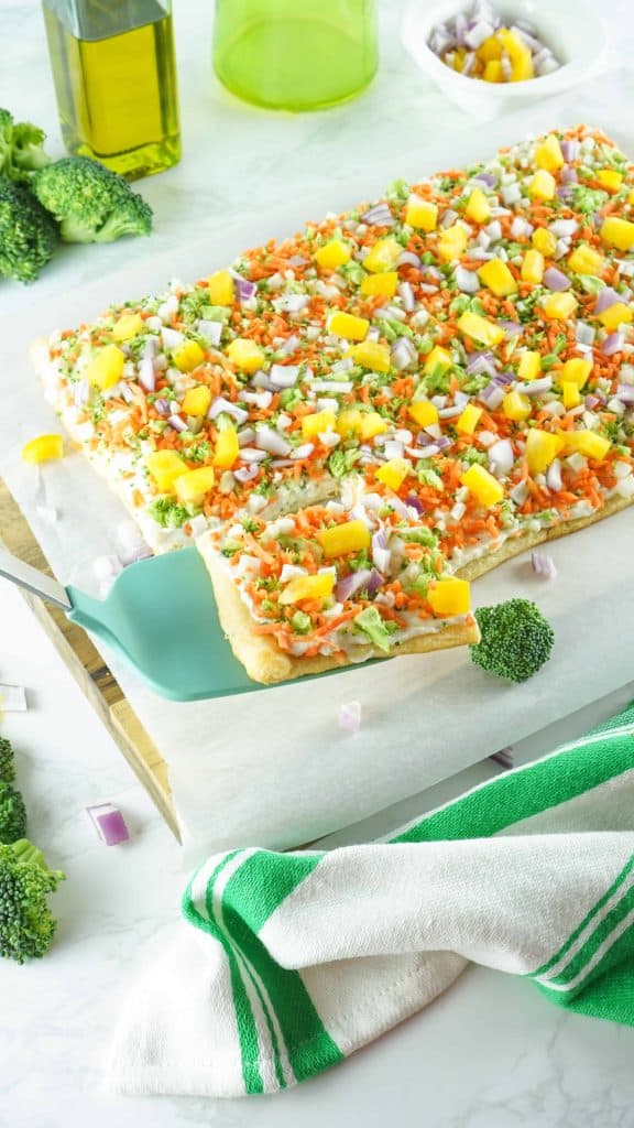 Sliced veggie bars with a piece on a light blue spatula