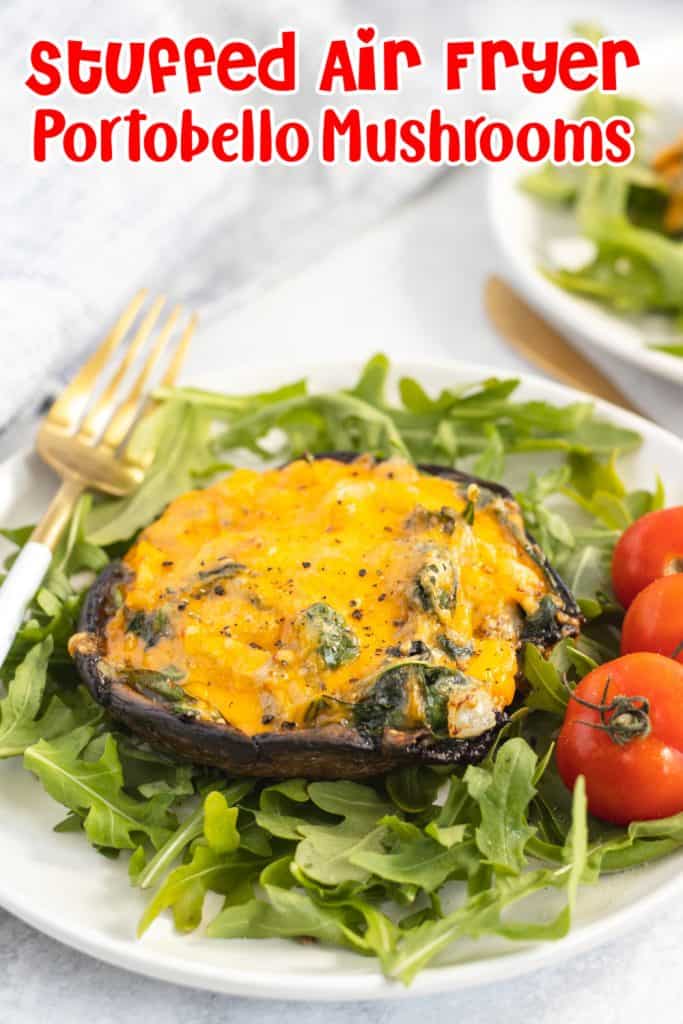 Stuffed portobello mushrooms with cheese on a bed of spinach with cherry tomatoes