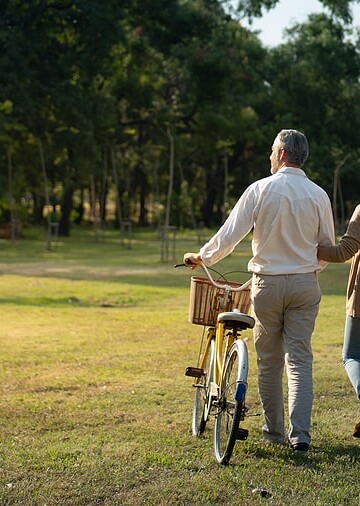 Save Download Preview The behind of Caucasian elderly couples walking with a bicycle in the natural autumn sunlight garden feel cherish and love, concept elderly love, warm family, happy retirement, retirement lifestyle.