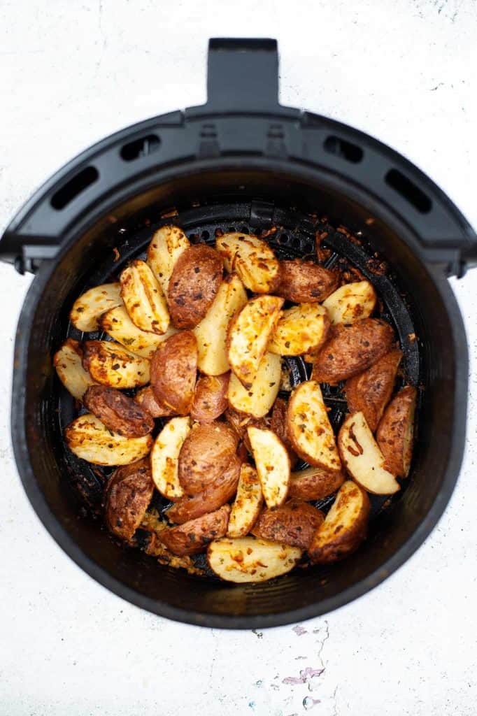 Potatoes in air fryer basket.
