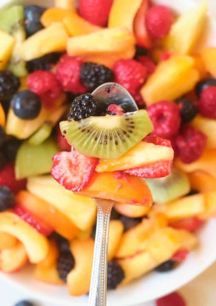 Berries and kiwi on a serving spoon.