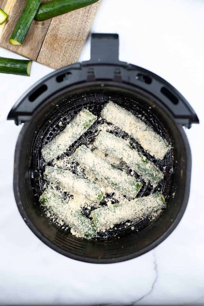 Overhead view of air fryer zucchini fries with Parmesan cheese.