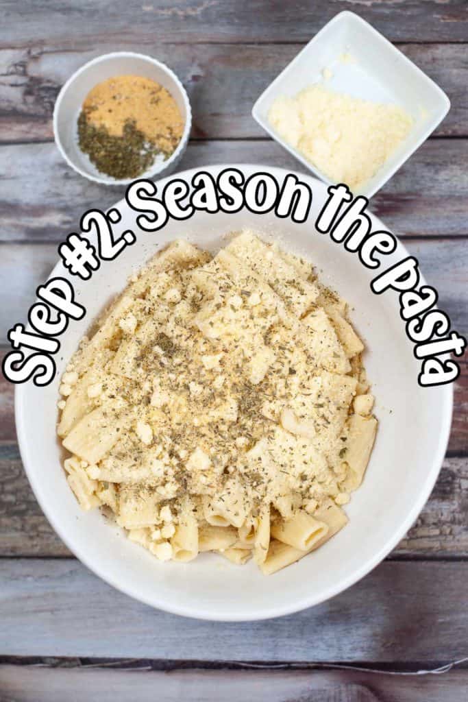 Rigatoni in a white bowl with cheese and herbs.