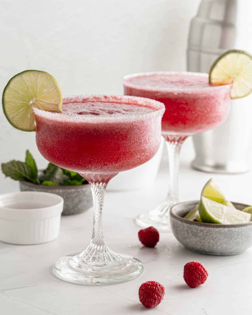 2 frozen drinks with fruit side by side.