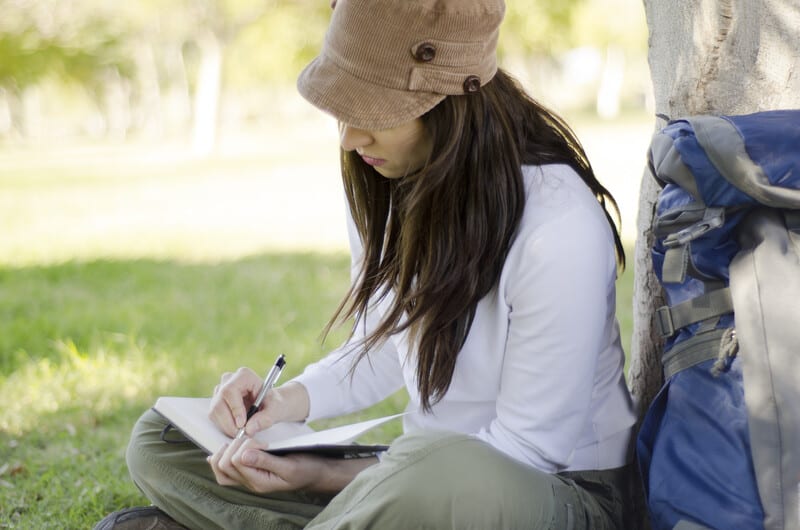 Woman writing in a journal.