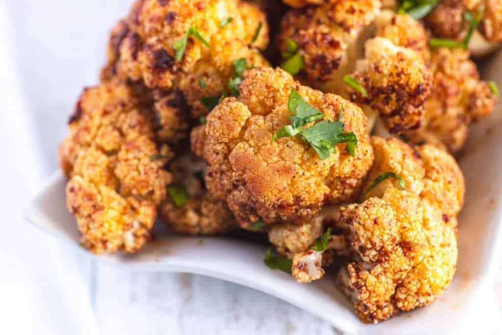 Spicy Harissa cauliflower with herbs sprinkled on top.