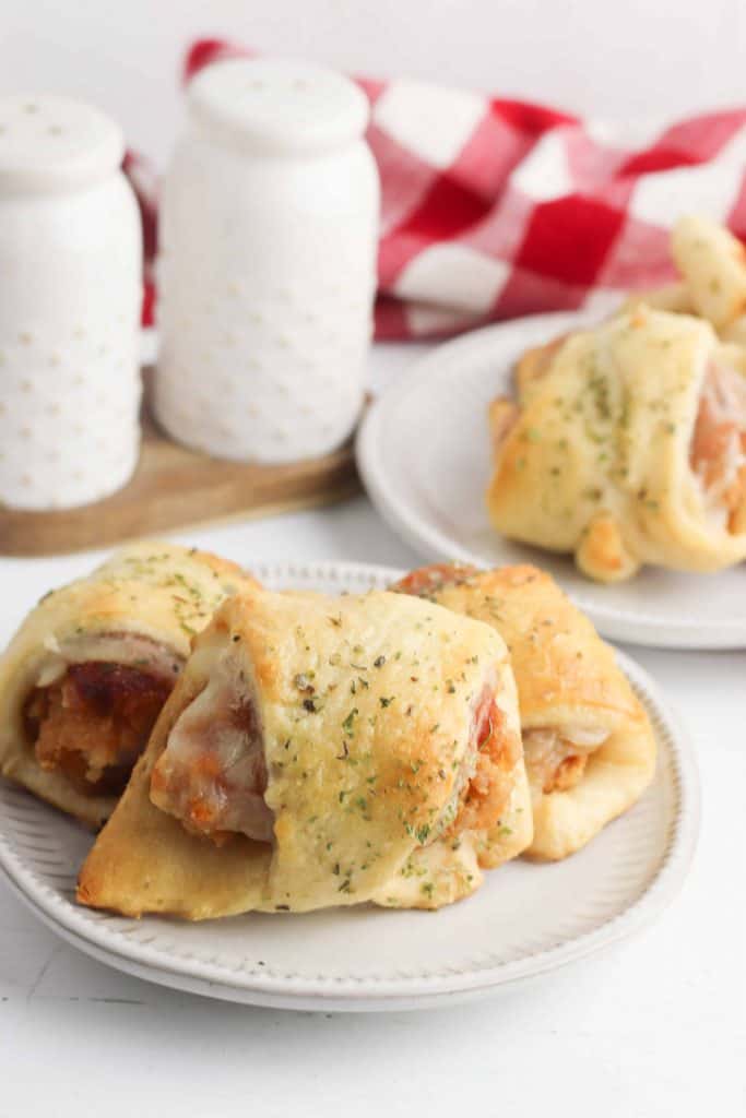 Chicken parmesan sliders on a white plate.