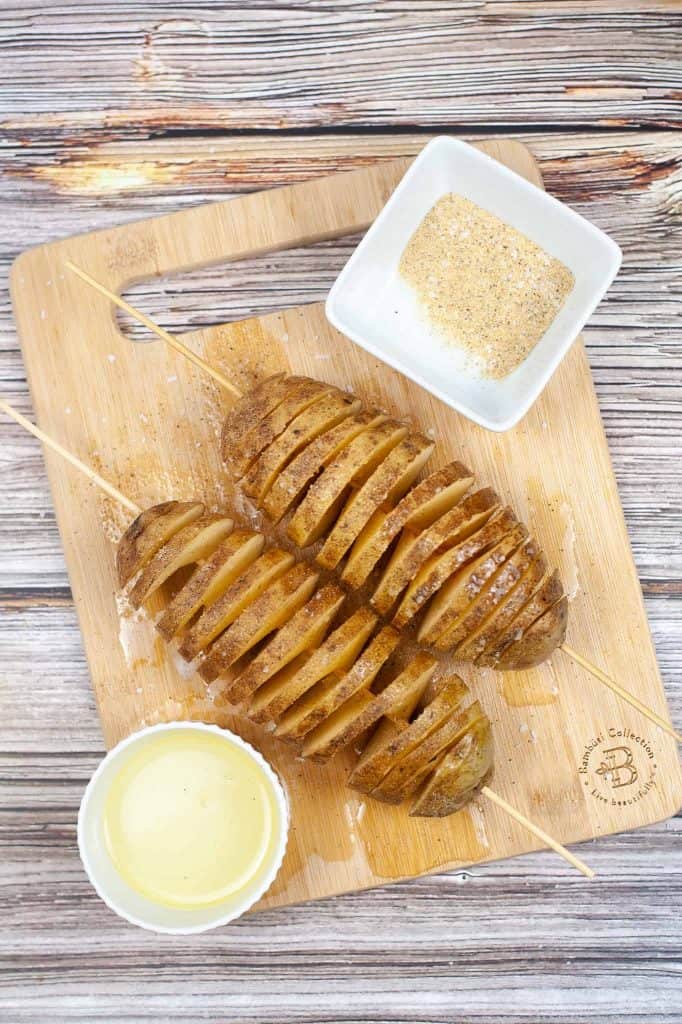 Skewered potatoes on a cutting board.