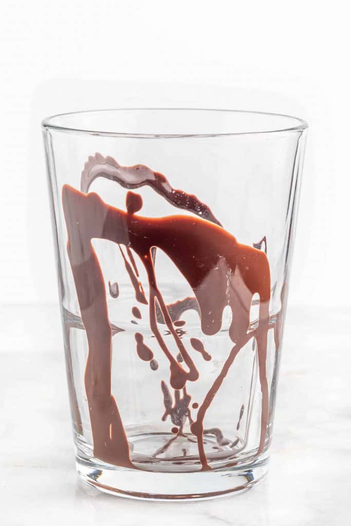 Chocolate sauce drizzled inside of a glass.