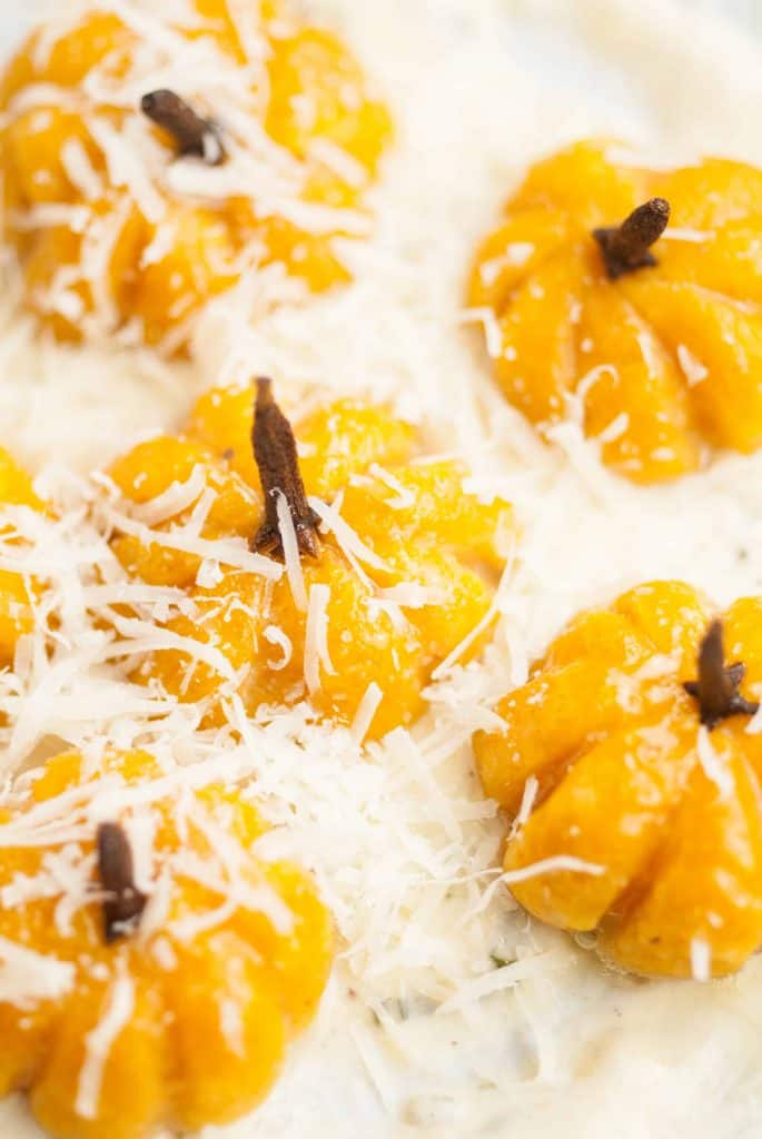 Close-up of pumpkin gnocchi topped with Parmesan cheese.