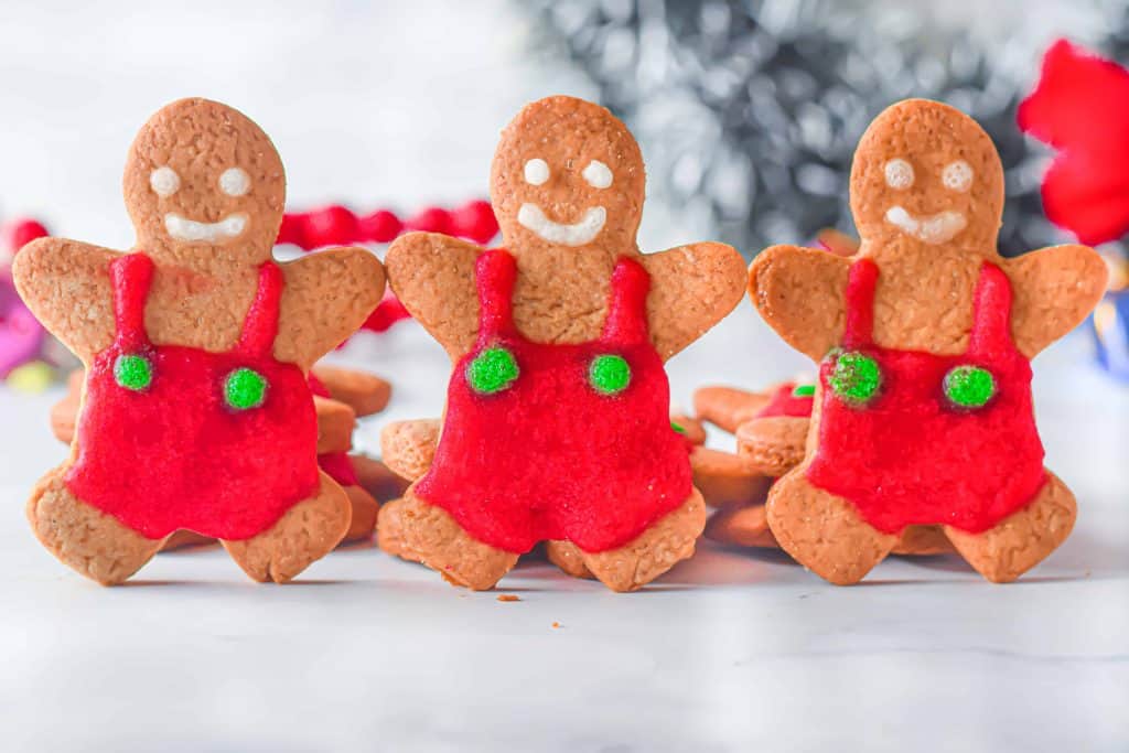 Three gingerbread men ständing up touching hands