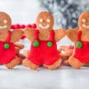 Three gingerbread men ständing up touching hands