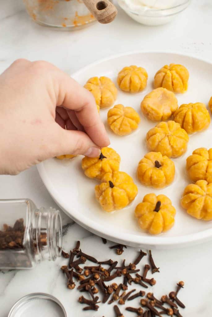 Putting cloves in pumpkin gnocchi.