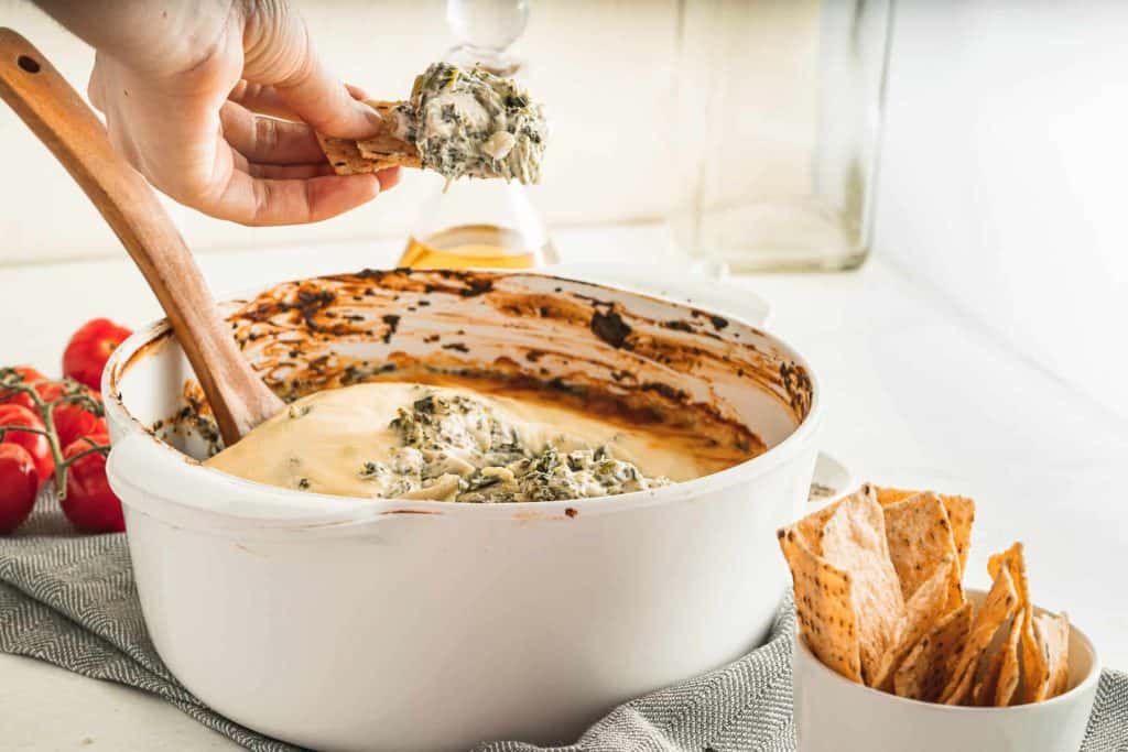 Chip dipped into artichoke spinach dip.