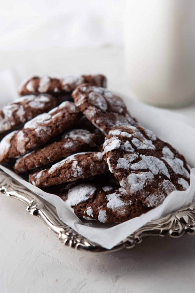 Chocolate crinkle cookies on a silver platter.