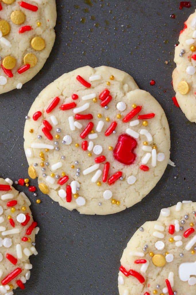 Cookies with sprinkles on a baking sheet.