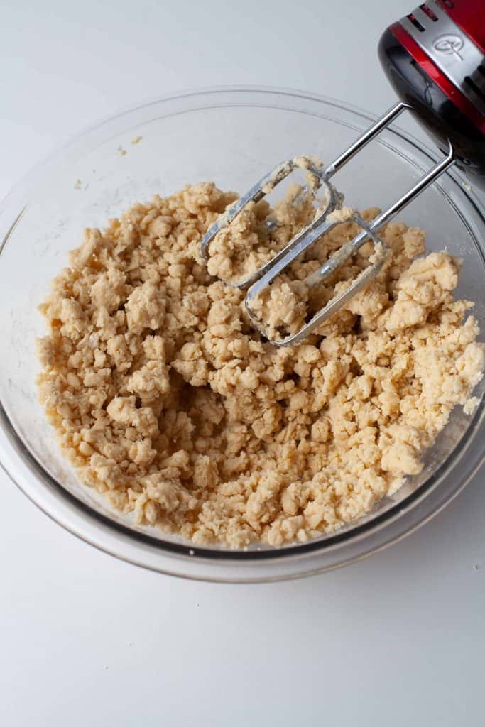 Cookie dough in a glass bowl with a blender on it's side.