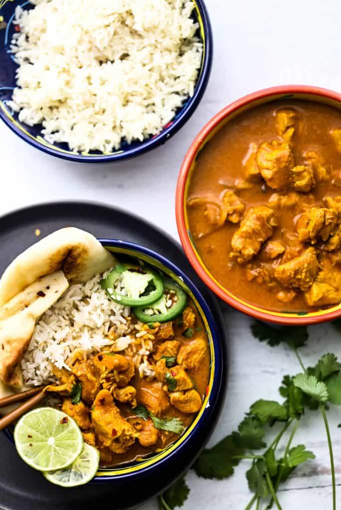 Butter chicken in a bowl with rice and naan.