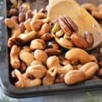 Oven roasted dill nuts on a wooden spoon.