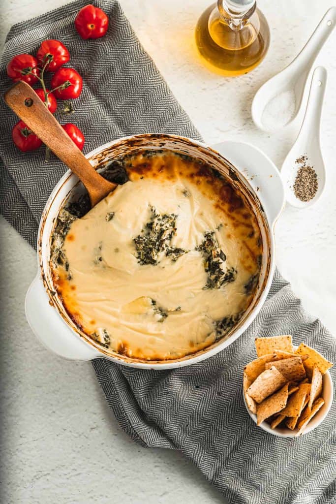 Overhead view of baked cheese dip with spinach and artichokes.