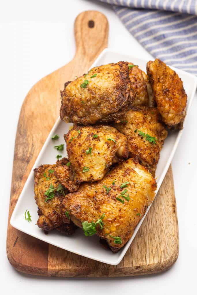 Chicken on plate on cutting board.