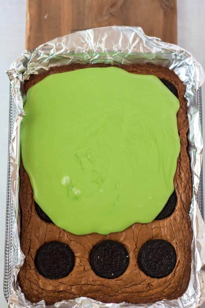 Green ganache poured over brownies.