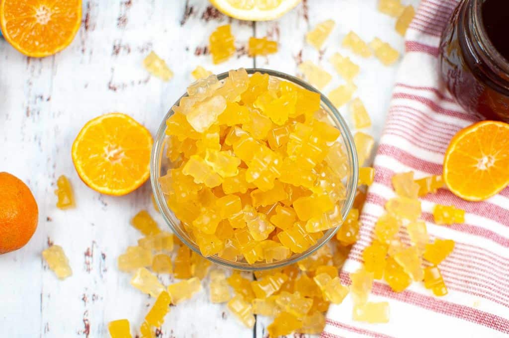 Orange fruit gummies in a bowl.