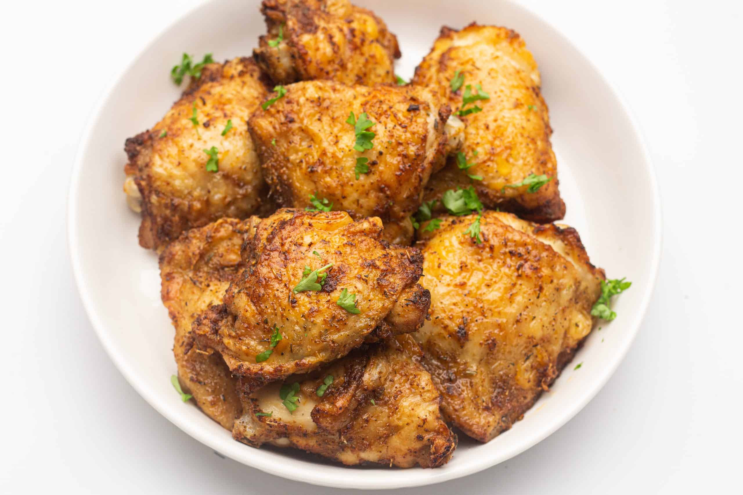 Overhead view of air fryer chicken thighs.