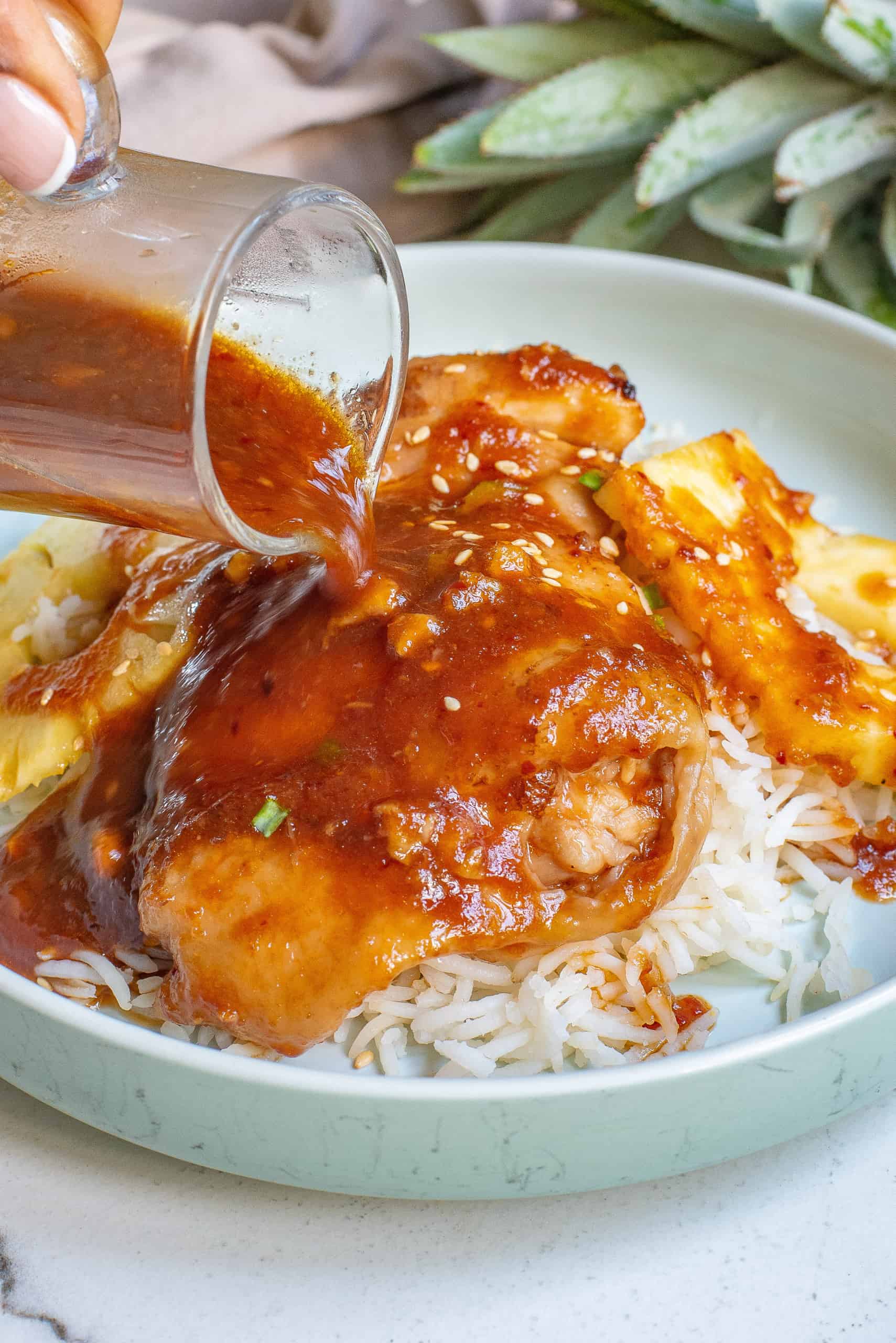 Pouring marinade over chicken thighs.