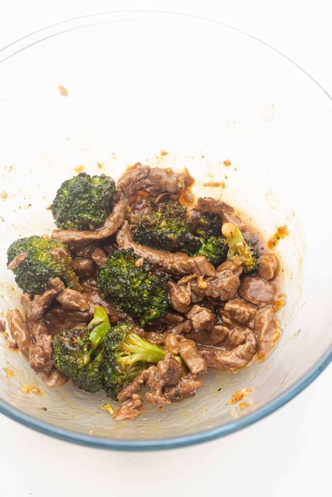 Beef and broccoli in sauce in a glass bowl.