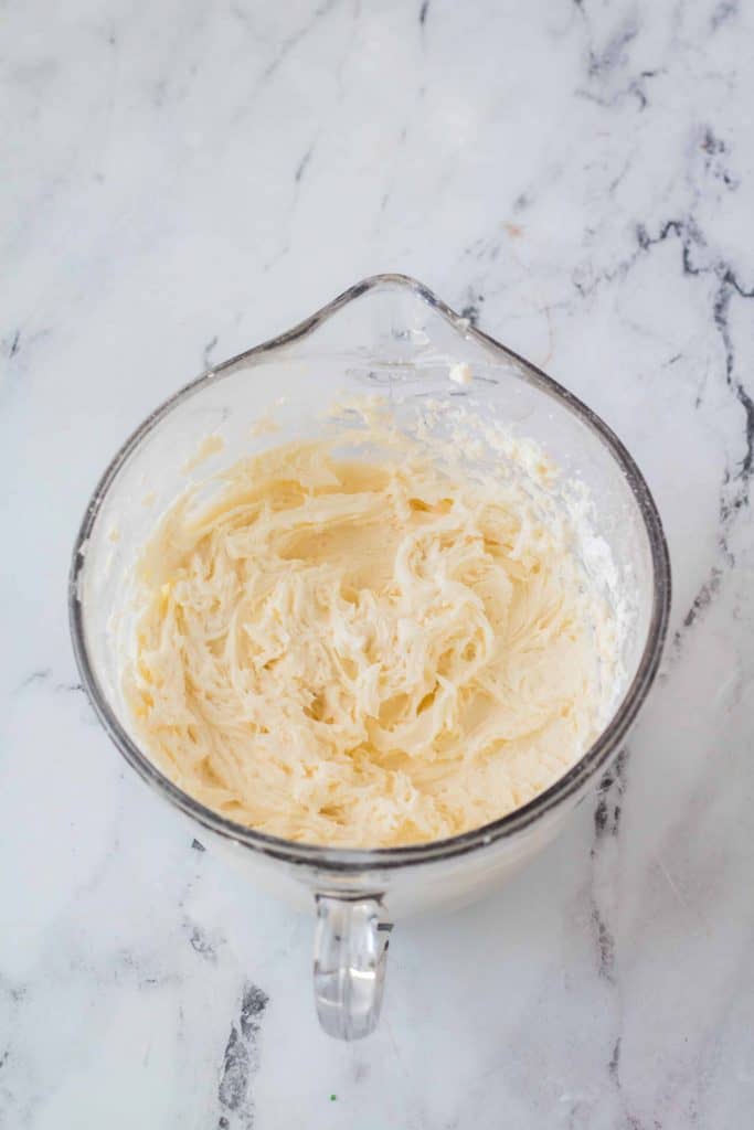 Buttercream frosting in a large glass bowl.