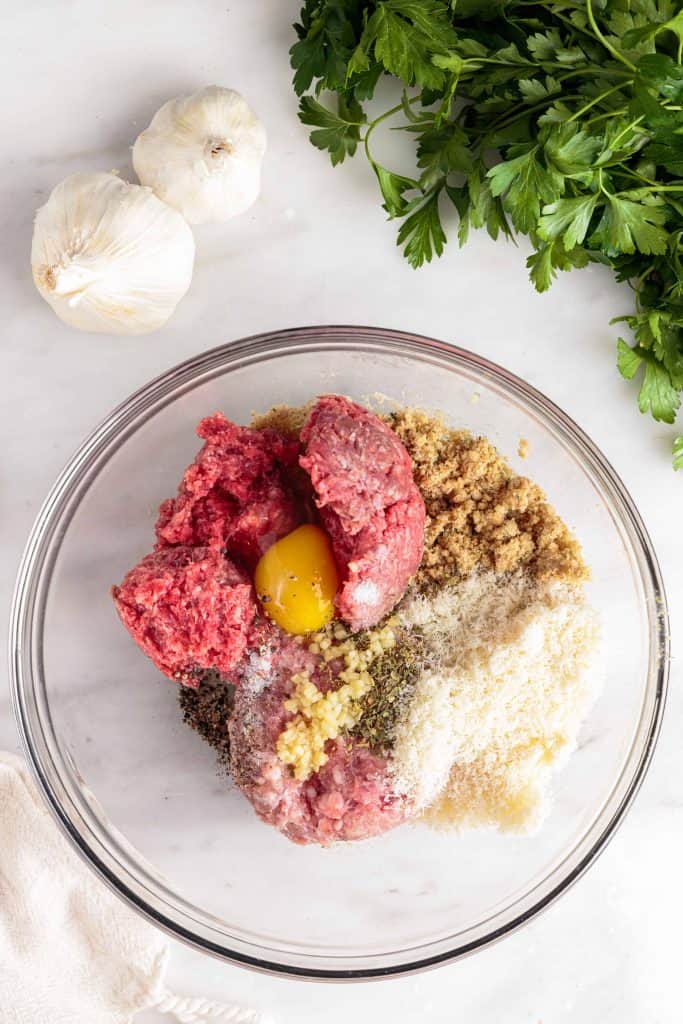 Meatball ingredients in a glass bowl.