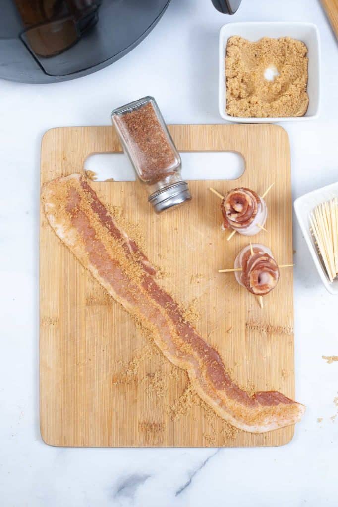 Raw bacon with brown sugar sprinkled on it.