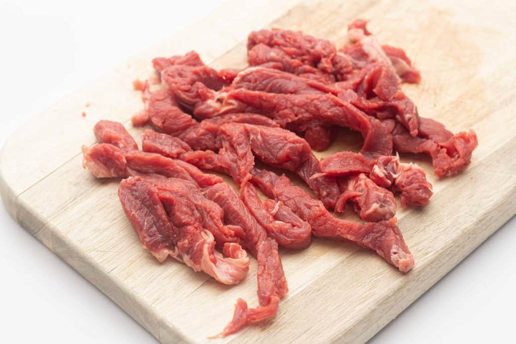 Sliced ribeye steaks on a cutting board.