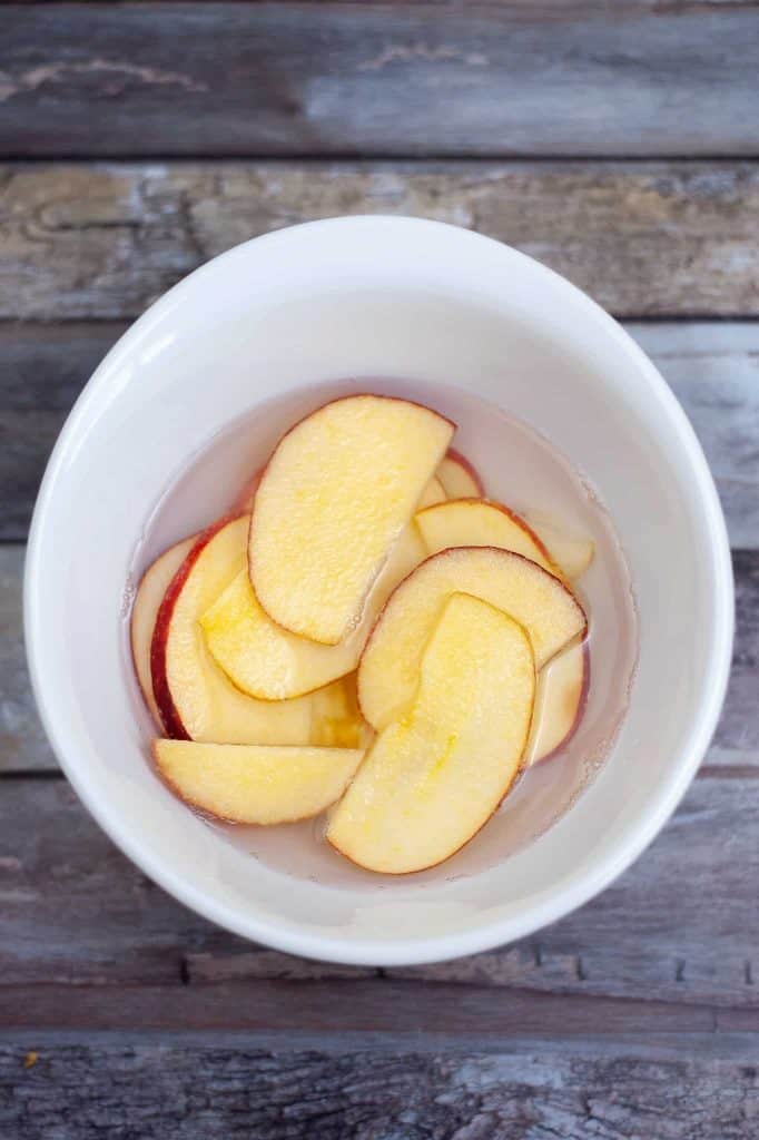 Apple slices in a bowl of water.