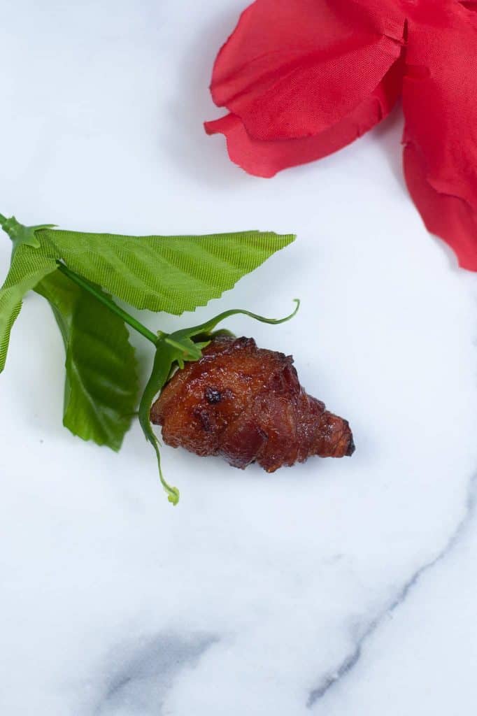 Closeup of candied bacon rose on stem.
