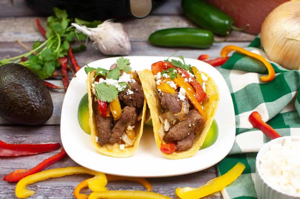 Beef fajitas on a white plate.
