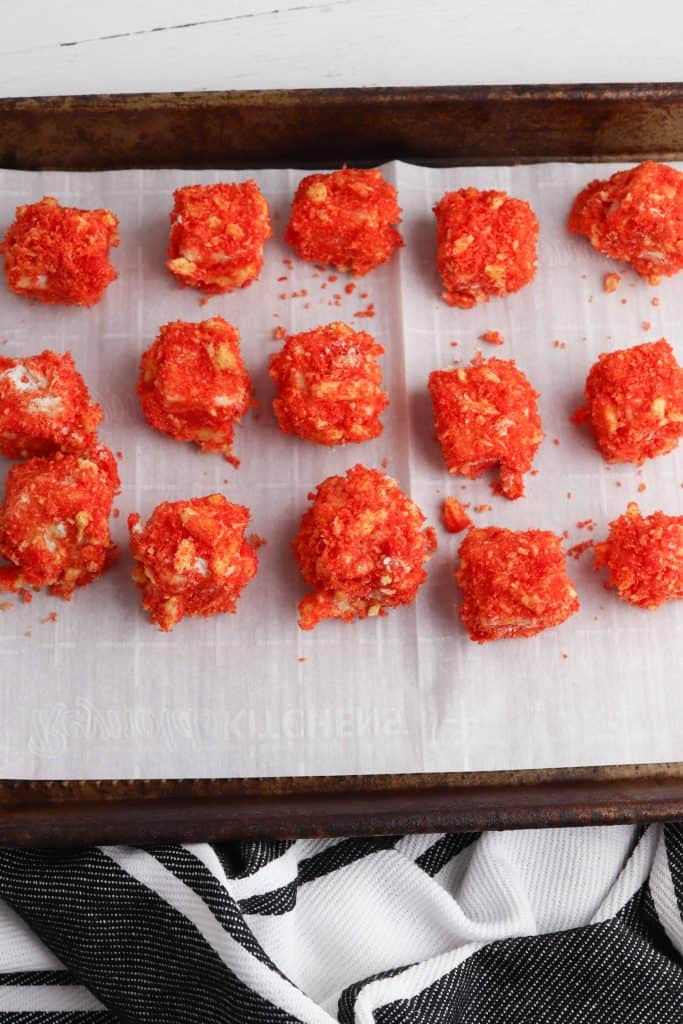 Cheetos cheese bites on lined baking sheet.