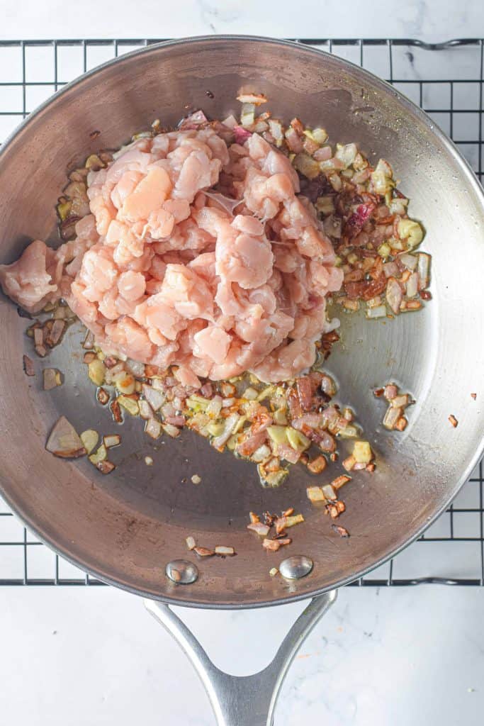 Chicken, garlic, and onions in a saute pan.